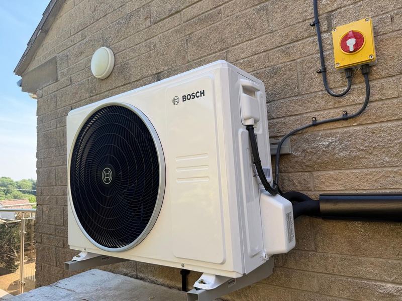 Bosch air conditioning outdoor unit fitted to a house wall